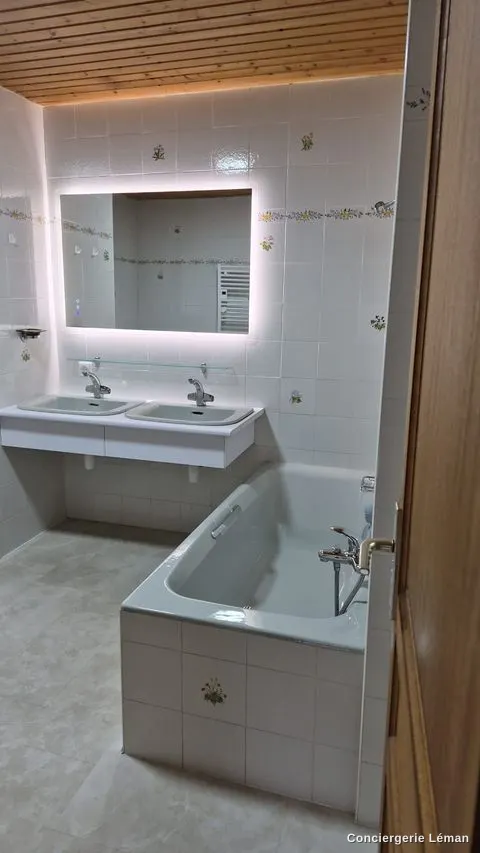 Salle de bains : double vasque, miroir et baignoire nettoyés