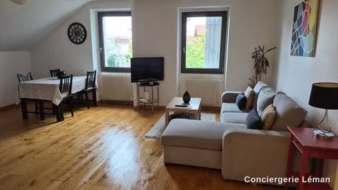 Séjour lumineux remis en ordre : coin repas, canapé d’angle et parquet propres