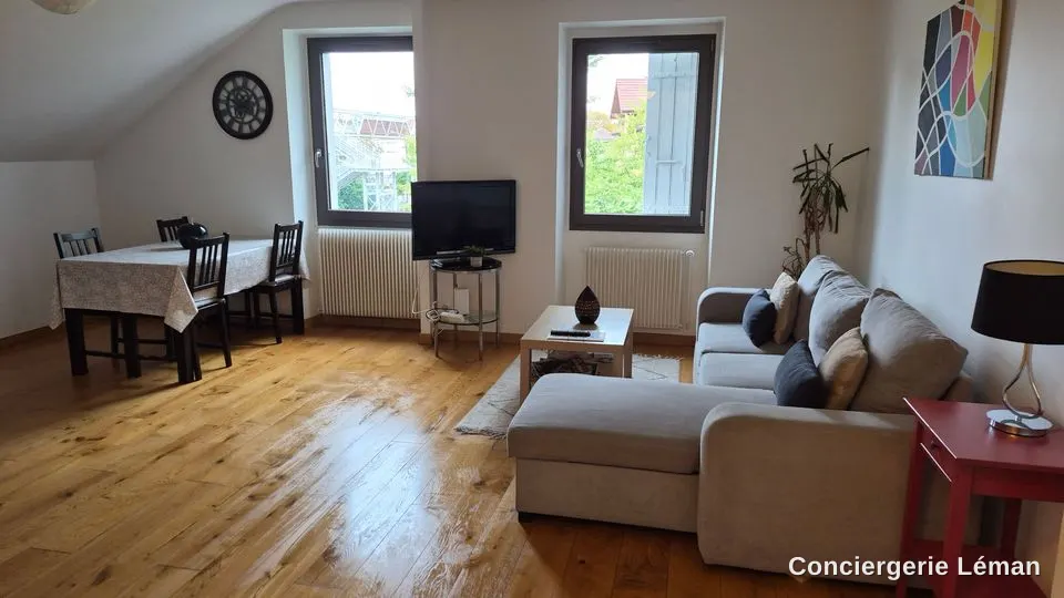 Séjour lumineux remis en ordre : coin repas, canapé d’angle et parquet propres